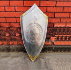 Decorative shield with emblem against a red brick wall