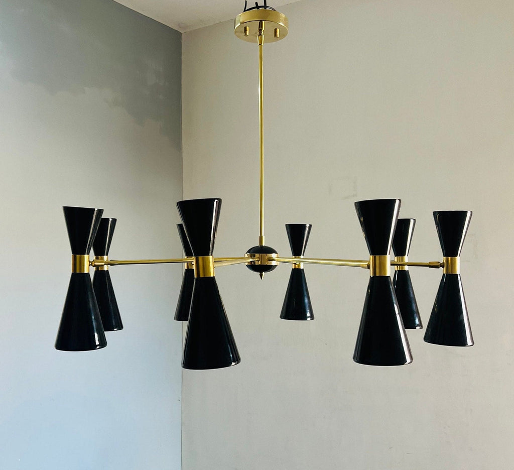 Modern chandelier with black and gold design on a neutral wall.