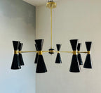Modern chandelier with black and gold design on a neutral wall.
