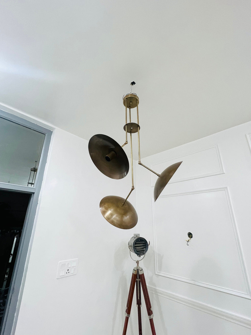Modern pendant light fixture hanging from a ceiling in a room with white walls.