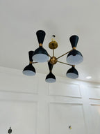 Modern chandelier with black and gold design on a white ceiling