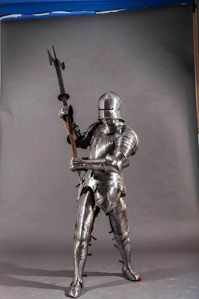 Full-body view of a person in medieval armor holding a spear against a gray background