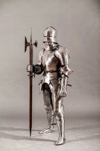 Full suit of medieval armor with a spear on a neutral background