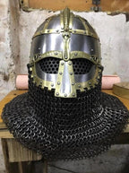 Viking-style helmet with chainmail on a wooden surface