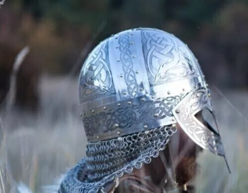 Decorative silver helmet with intricate designs on a blurred natural background
